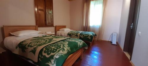 a hotel room with two beds and a window at Guest house Lekhtagi in Mestia