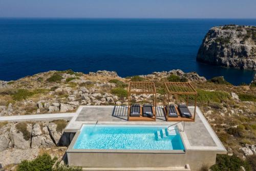 a pool on a cliff with the ocean in the background at Kouros Exclusive Hotel & Suites - Adults Only in Faliraki