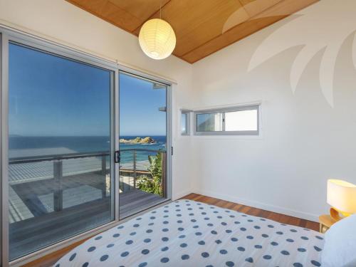 a bedroom with a bed and a view of the ocean at Sea Shack in Seal Rocks