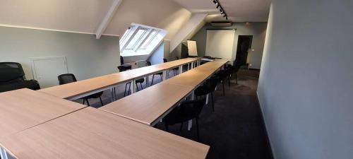 a row of tables and chairs in a room at Hostellerie Saint Vincent Beauvais Aeroport in Beauvais