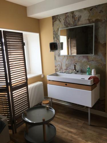 ein Badezimmer mit Waschbecken und Spiegel in der Unterkunft Suite en Terrasse à Cognac in Cognac