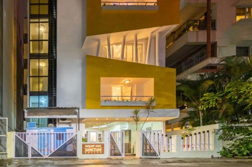 a modern house with a yellow facade at Sanctum Suites Domlur Bangalore in Bengaluru