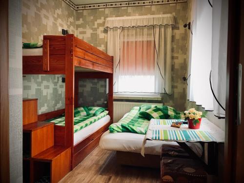 a bedroom with two bunk beds and a table at Pokoje Goscinne Gallick in Gdynia