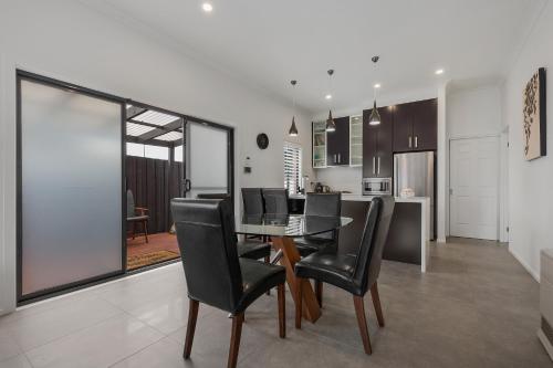 comedor y cocina con mesa y sillas en Chic 2 Bedroom Keilor, en St Albans