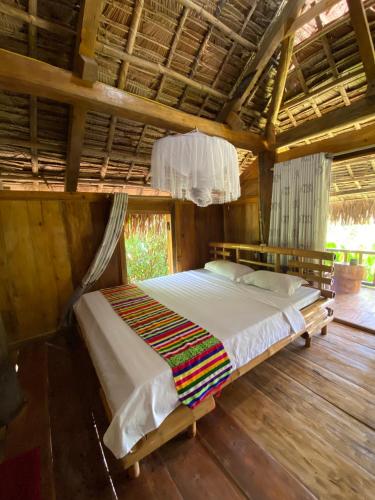 a bedroom with a bed in a wooden room at Pù Luông Ecolodge in Pu Luong