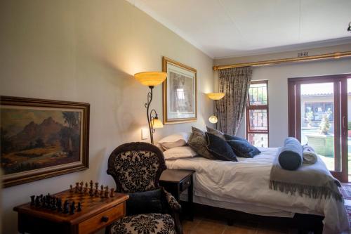 a bedroom with a king sized bed and a chess board at Antiqua Guest House in George