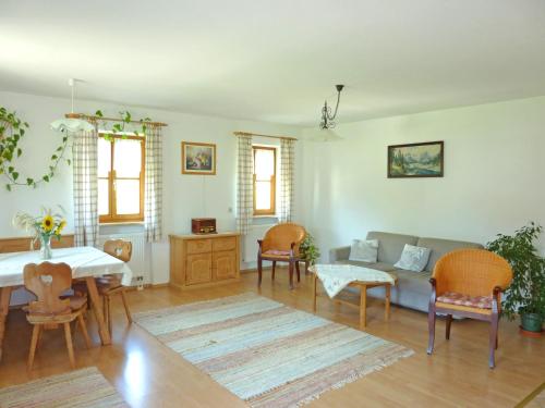 a living room with a couch and a table and chairs at Ferienwohnungen Maurer Höhenberg in Aschau im Chiemgau