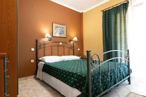 een slaapkamer met een bed met een groen dekbed bij Amfitrion in Gythio