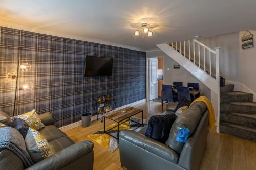 a living room with a couch and a tv at Number Four in Westoe