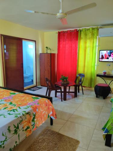 a room with colorful curtains and a table and chairs at Bob Apartments in Calodyne