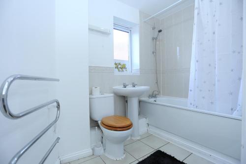 a white bathroom with a toilet and a sink at 2 Bedroom Apartment in Thamesmead
