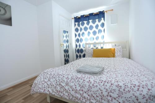 a small bedroom with a bed with a yellow pillow at 2 Bedroom Apartment in Thamesmead