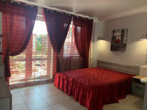 a bedroom with a red bed in front of a window at Апартаменти Маяк in Odesa