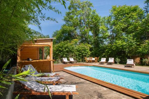 - une piscine avec des chaises longues à côté dans l'établissement Chambre d'Hôtes Au Jardin Des Saveurs, à Cordes-sur-Ciel