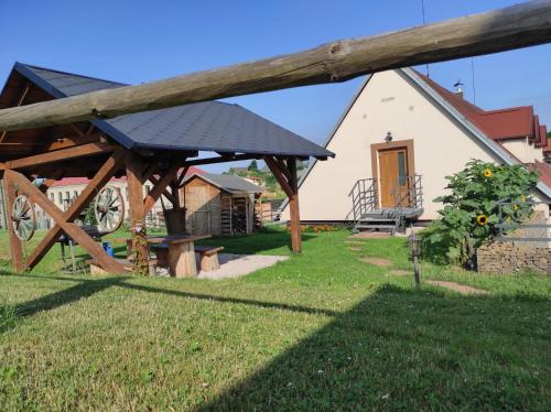 a wooden pavilion in front of a house at Apartmán na statku Červený Kostelec in Červený Kostelec
