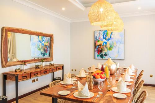 a dining room with a table and a mirror at The S Holiday Homes - Stunning 5 Bedrooms Villa at the Palm Jumeirah with Private Beach and Pool in Dubai