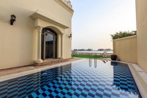 a swimming pool in a house with a blue tile floor at The S Holiday Homes - Stunning 5 Bedrooms Villa at the Palm Jumeirah with Private Beach and Pool in Dubai