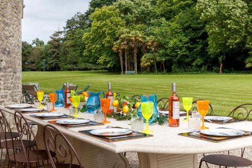een lange tafel met wijnglazen en een veld bij Chateau de Servigny in Yvetot Bocage