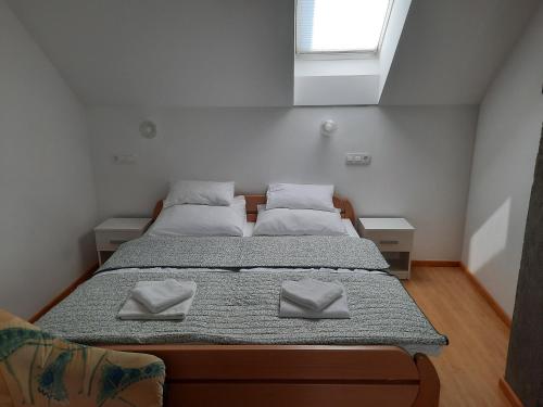 una camera con 2 letti con cuscini bianchi e una finestra di Apartma Šmid a Škofja Loka
