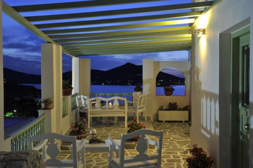 a porch with white chairs and a view of the ocean at Villa Isabella in Naousa
