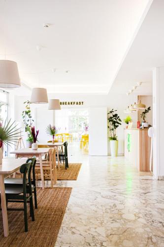 a dining room with tables and chairs and plants at Hotel Blumen in San Benedetto del Tronto