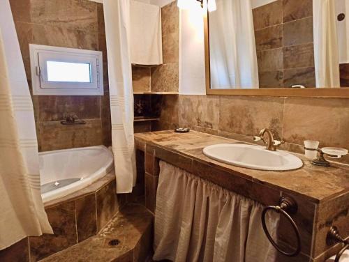 ein Badezimmer mit einem Waschbecken und einer Badewanne in der Unterkunft Pantheon in Serres