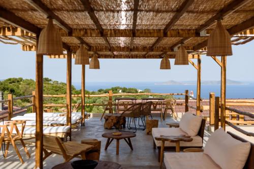 un patio con tavoli, sedie e vista sull'oceano di ALETRI new swim up HOTEL a Città di Alonissos