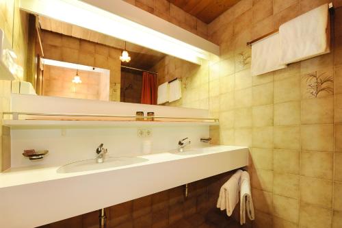 ein Badezimmer mit 2 Waschbecken und einem Spiegel in der Unterkunft Frühstückspension Haus Kreuzmayr in Gaschurn