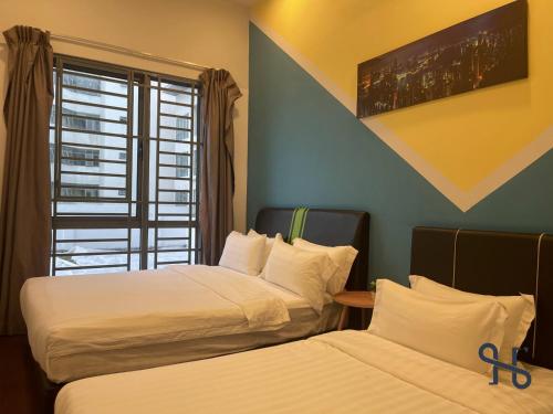 two beds in a hotel room with a window at Homesuite' Home at The Loft in Kota Kinabalu
