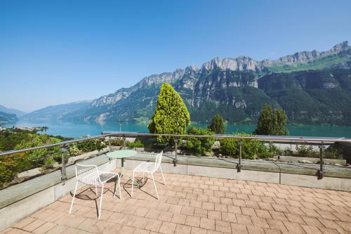 a patio with a table and chairs and a view of a lake at Hotel Neu-Schönstatt in Quarten