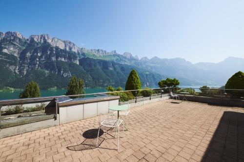 two chairs and a table on a patio overlooking a mountain at Hotel Neu-Schönstatt in Quarten