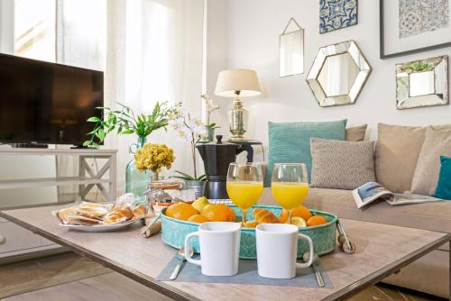 a table with oranges and glasses of orange juice at Genteel Home Litoral in Málaga