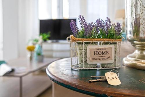 a table with a basket of flowers and a bunch of keys at Genteel Home Litoral in Málaga