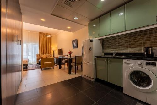 a kitchen with a washing machine and a dining room at Gulf Oasis Hotel Apartments Fz LLC in Dubai
