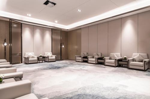a waiting room with couches and chairs in a room at Pullman Jiaxing Pinghu Excellence in Jiaxing