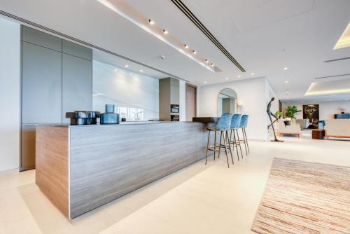 een keuken met een bar met blauwe krukken bij Palm Jumeirah Luxury Apartments by Propr in Dubai