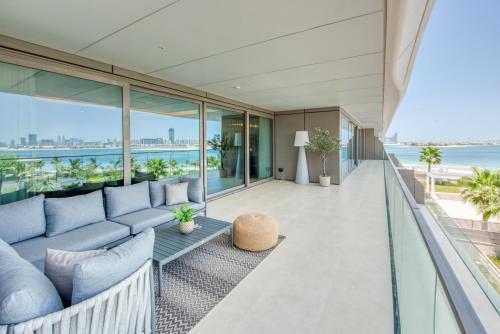 een open woonkamer met een blauwe bank op een balkon bij Palm Jumeirah Luxury Apartments by Propr in Dubai