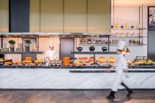 a person walking in front of a buffet at Pullman Jiaxing Pinghu Excellence in Jiaxing