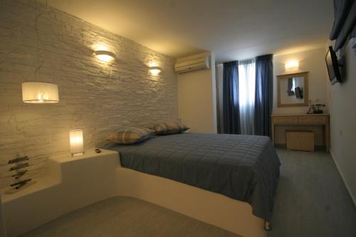 a bedroom with a bed and a stone wall at Villa Isabella in Naousa