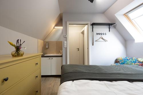 a attic bedroom with a bed and a kitchen at Penzion Pod hrádkem in Mikulov