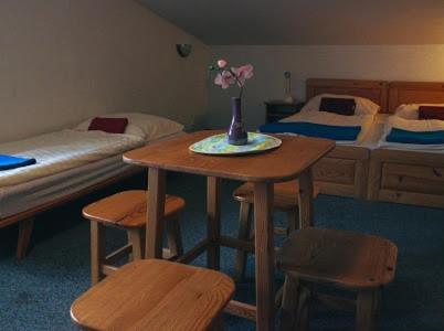 a room with two beds and a table and two beds at Chata Jamy in Vysoke Tatry - Tatranska Lomnica.