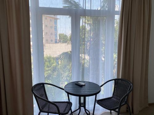 ラザレフスコエにあるGuest House Evaの大きな窓の前にテーブルと椅子