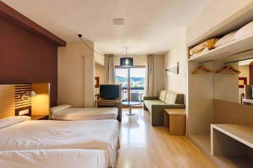 a hotel room with two beds and a television at Oroel Hotel & SPA in Jaca