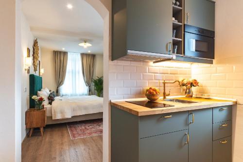 a kitchen with a sink and a room with a bed at Nikolas Haus in Braşov