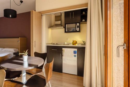 a kitchen and a table and chairs in a room at Oroel Hotel & SPA in Jaca