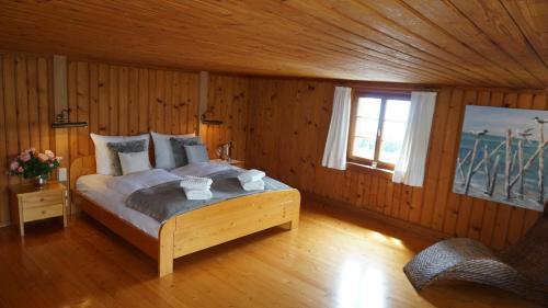 ein Schlafzimmer mit einem großen Bett in einem Holzzimmer in der Unterkunft Bauernhaus am Pfänderhang mit Seeblick in Lochau