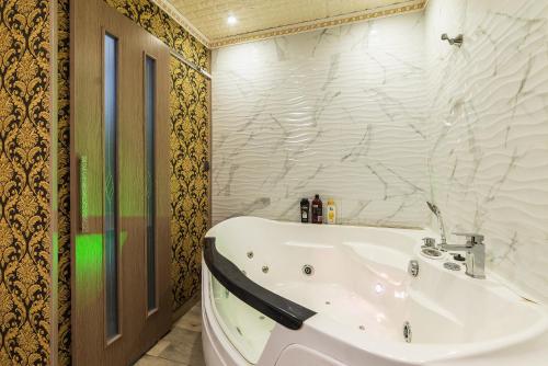 a bathroom with a tub and a white sink at Смарт Апартаменты джакузи in Dnipro
