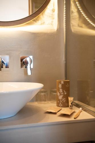 a bathroom counter with a white sink and a mirror at The Authentic Village Boutique Hotel in Khóra Sfakíon