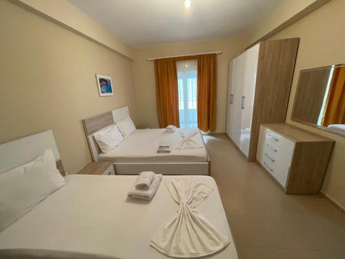 a small room with two beds and a bed and a dresser at Premium Apartaments 02-03 in Vlorë