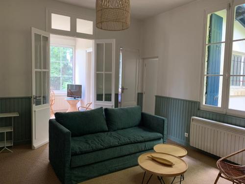 sala de estar con sofá verde y mesa en Villa Marguerite, en Lège-Cap-Ferret